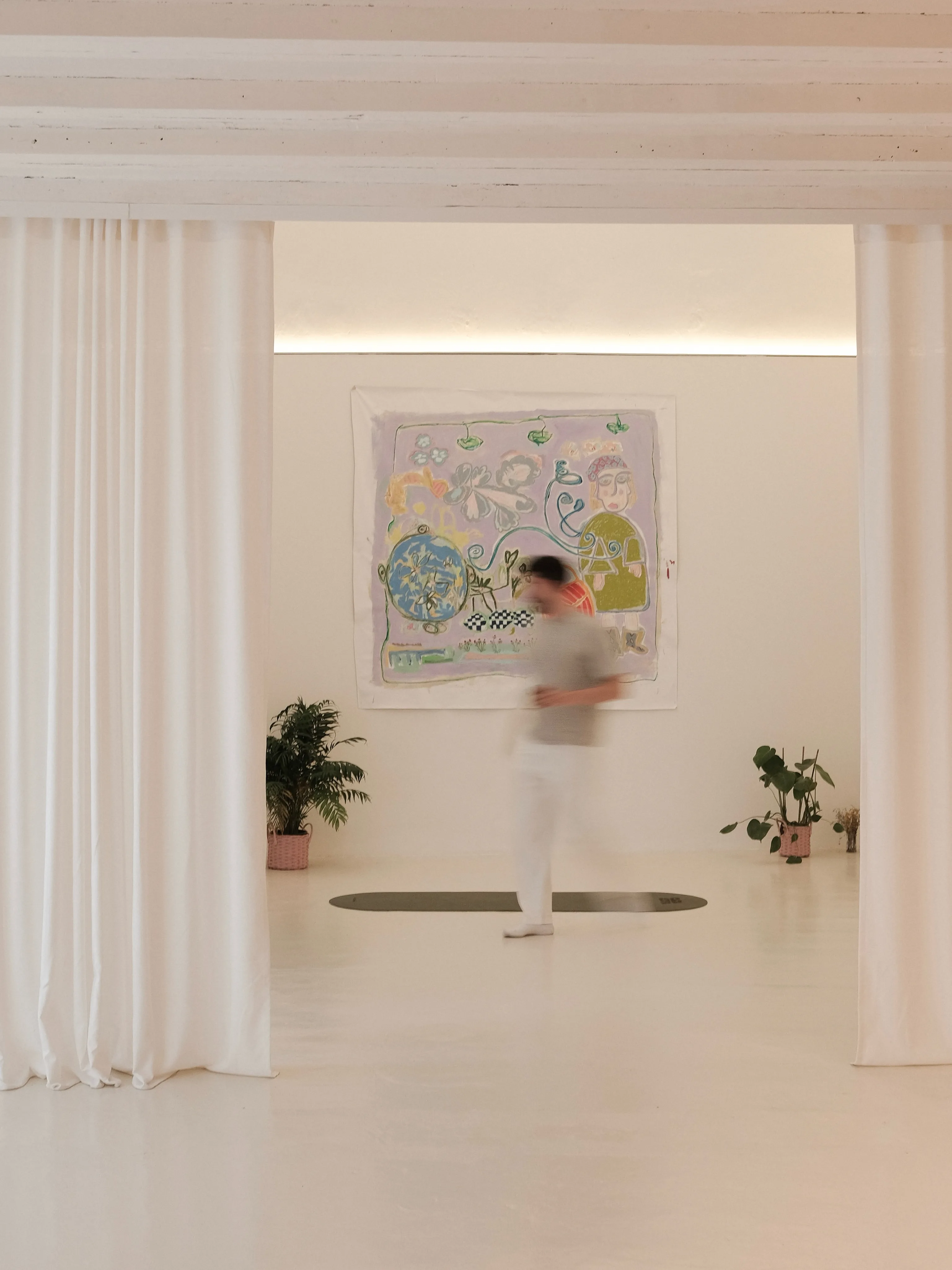Una persona cruzando la sala frente a una obra de arte